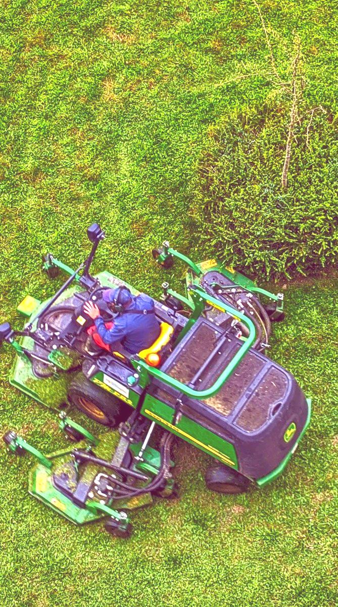 green and black ride on lawn mower on green grass field during daytime